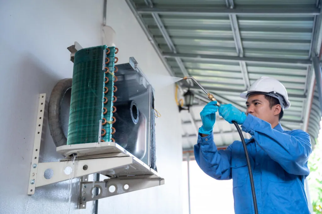 A technician performing routine maintenance on an air conditioner in a Melbourne home.