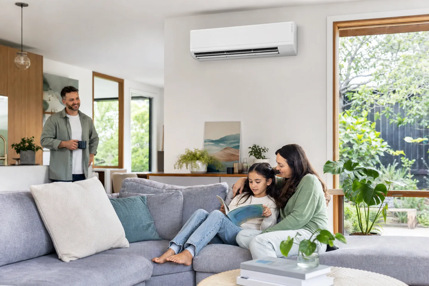 Family relaxing beneath a wall-mounted split system air conditioner in a bright Melbourne living room